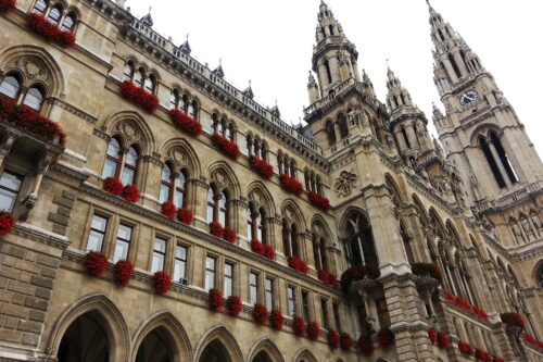 Front of an histroric building with red flowers in the windows